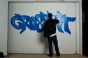Graphic Artist "Fat Head" tagging a wall at Warehouse 20
